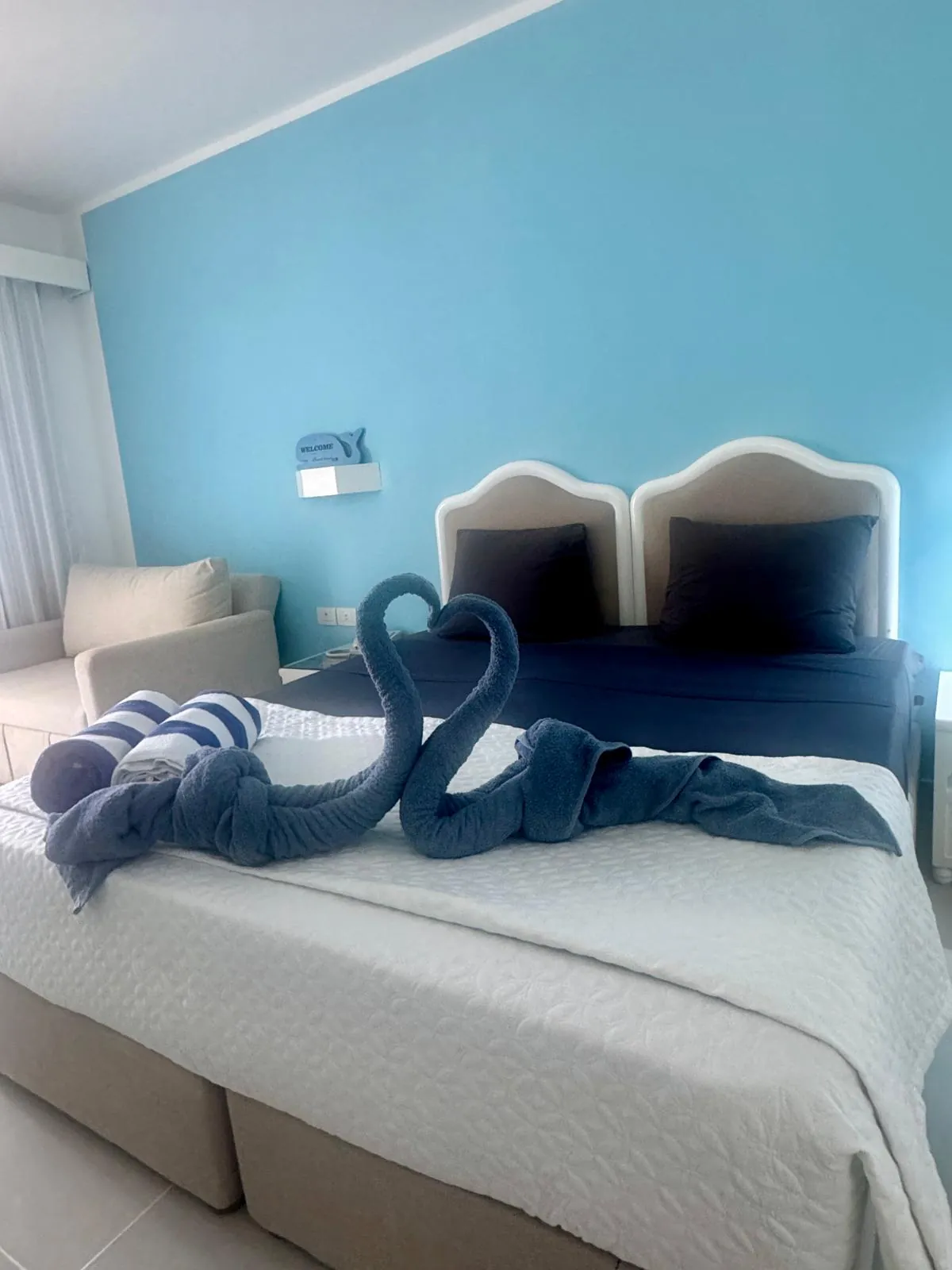 Camera matrimoniale con parete azzurra e asciugamani a forma di cigno, La Stanza di Gabriele al Coral Bay